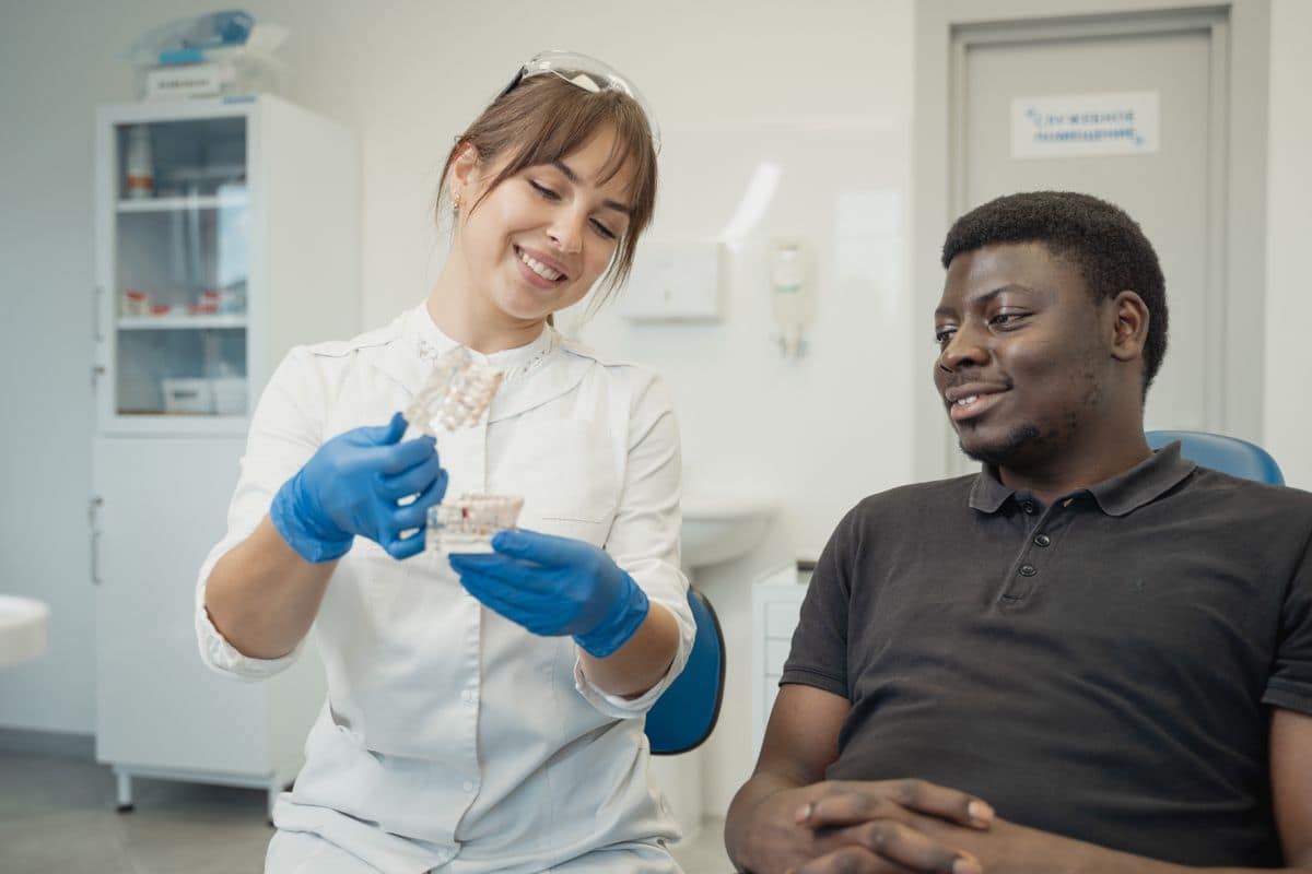 Une hygiéniste de la clinique avec un patient, pendant un examen